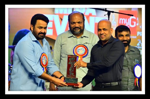 Rajesh Puthanpurayil accepting an award from Mohanlal