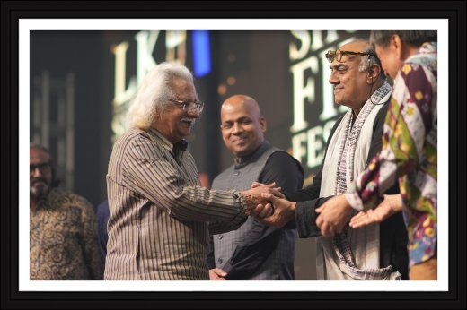 Adoor Gopalakrishnan greeting Rajesh Puthanpurayil on stage at LK International Short Film Festival 2026